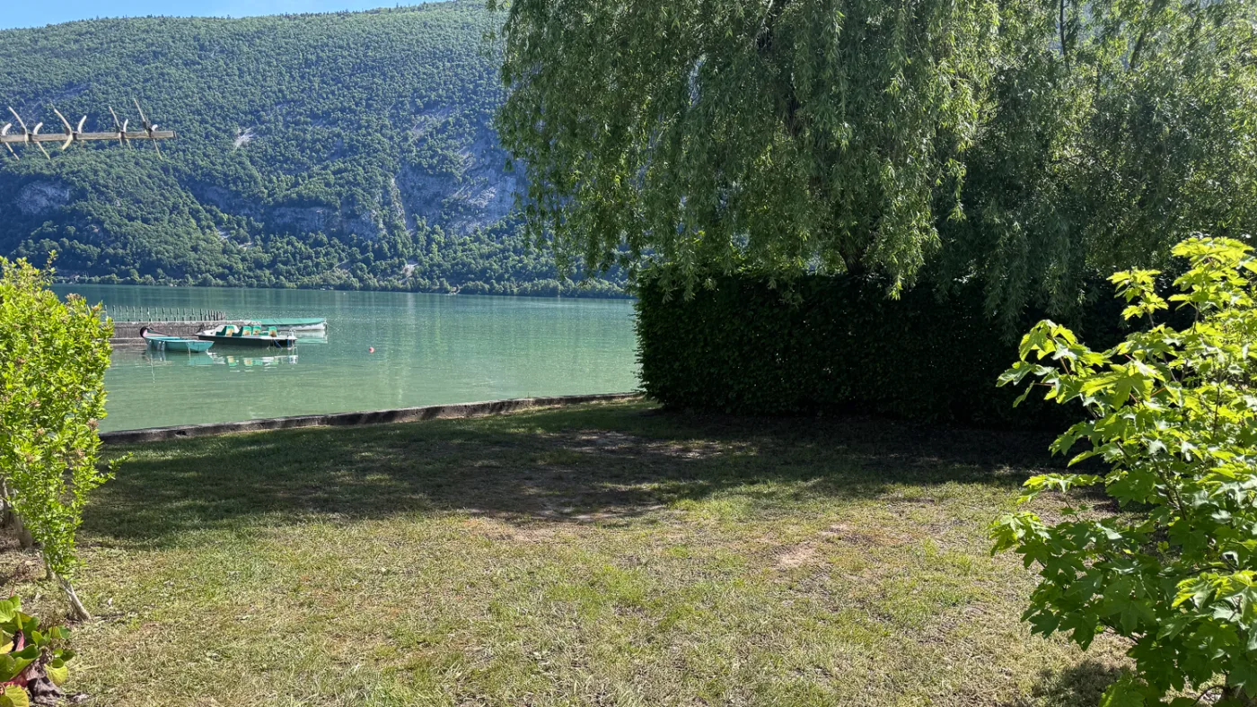 Pelouse au bord du lac d'Aiguebelette avec barques au ponton